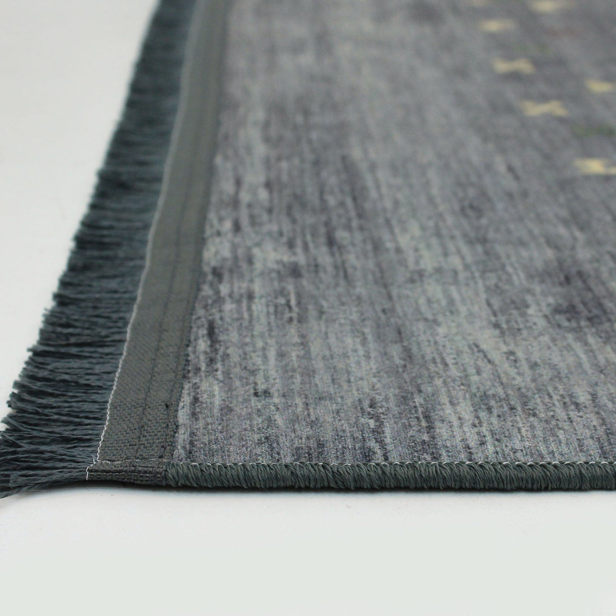 Esquina de la alfombra oriental 'Cedar', mostrando detalles de los pequeños animales que decoran el borde y partes del patrón hipnótico. Aporta un encanto especial y autenticidad a cualquier espacio. Lavable en lavadora, base antideslizante, sin pelusas e hipoalergénica.