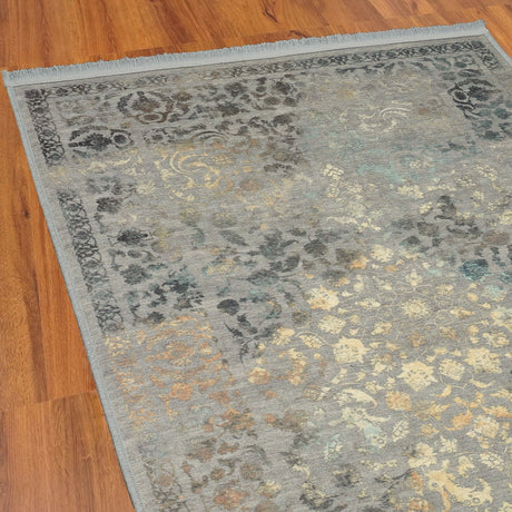 Esquina de la alfombra 'Glimmer', mostrando el detalle de su diseño en tonos suaves y dorados. Este patrón detallado y elegante aporta un toque de lujo y sofisticación a cualquier espacio, ideal para realzar la decoración de salones, dormitorios o estudios con un estilo cálido y acogedor. Lavable en lavadora, base antideslizante, sin pelusas e hipoalergénica.
