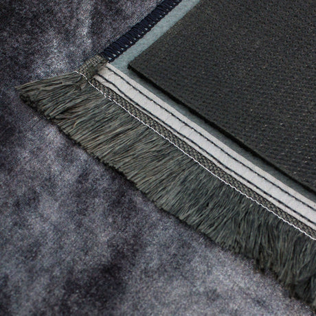 Vista completa del frente y reverso de la alfombra 'Prestige', resaltando su diseño abstracto en tonos grises y dorados. La base antideslizante y el diseño lavable en lavadora combinan estilo con funcionalidad.